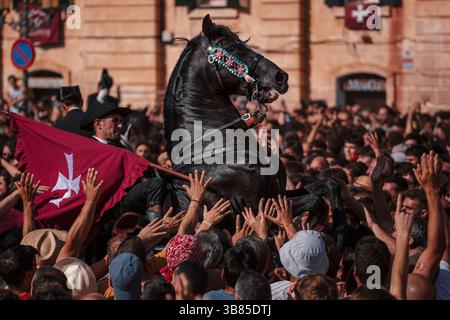 23 juin 2024, Ciutadella de Menorca, Îles Baléares, Espagne : le 'caixer fabri' (porteur de drapeau) se lève sur son cheval entouré d'une foule enthousiaste pendant le 'Caragol des Born' (défilé de chevaux) à la veille du traditionnel 'Sant Joan' (Saint Jean) festival. (Crédit image : © Matthias Oesterle/ZUMA Press Wire) Banque D'Images