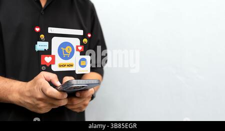 Gros plan d'un homme tenant un smartphone, portant une chemise noire, utilisant un appareil mobile pour la messagerie, la navigation ou le commerce en ligne Banque D'Images