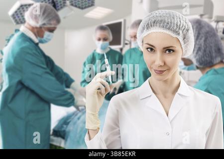 Jeune femme anesthésiste avec seringue sur l'arrière-plan teem chirurgie Banque D'Images