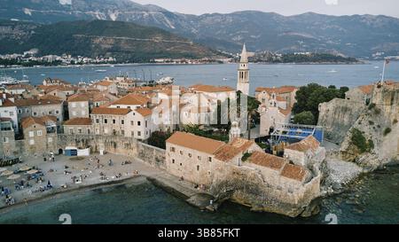 Murs de la forteresse en pierre de la vieille ville près du haut clocher. Budva, Monténégro. Drone. Banque D'Images