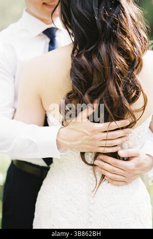 Les mains du marié sont sur le dos de la mariée. Gros plan. Banque D'Images