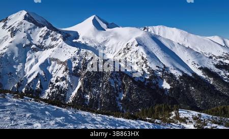 Vue aérienne au-dessus des montagnes Pirin avec des sommets rocheux recouverts de neige. Vue d'hiver à la station de ski de Bansko en Bulgarie Banque D'Images