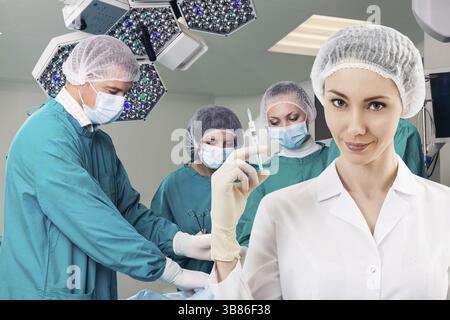 Jeune femme anesthésiste avec seringue sur l'arrière-plan teem chirurgie Banque D'Images