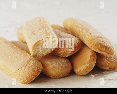 Vue rapprochée du biscuit ladyfinger sur fond de béton blanc. Biscuit italien savoiardi Banque D'Images