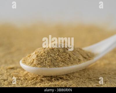 La levure alimentaire contexte. Levure inactive nutritionnel en blanc cuillère. Copier l'espace. La levure alimentaire est végétarien superfood avec fromage saveur, pour Banque D'Images