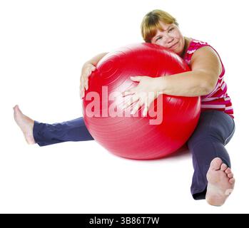 Grosse femme fatiguée avec une grosse balle de gymnastique rouge Banque D'Images
