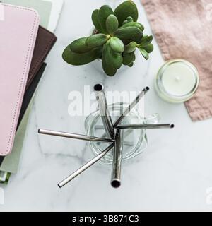 Pailles à boire en métal dans un pot en verre maçon sur table en marbre blanc à l'intérieur. Pailles en métal sur la table dans le salon intérieur. Pailles recyclables, zéro déchet CO Banque D'Images