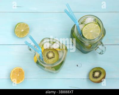 Limonade maison à froid avec des produits frais de citron, de limette, kiwi et menthe en pot Mason. Boisson d'été bleu clair sur fond de bois. Télévision laïcs ou Vue de dessus Banque D'Images