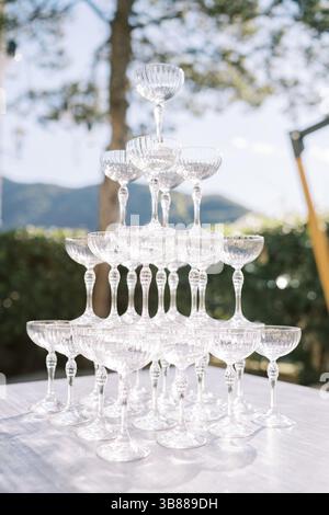 Pyramide de verres vides se dresse sur une table dans le jardin. Banque D'Images