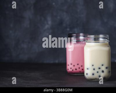 Le lait fait maison bubble tea avec perles de tapioca de boules. Taiwan populaires bubble tea dans verre pot Mason avec copie espace pour le texte. Deux bubble tea sur dark retour Banque D'Images