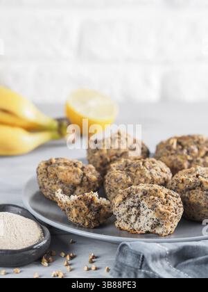 Vue rapprochée d'une homemmade sans gluten muffins aux bananes avec de la farine de sarrasin. Vegan muffins aux graines de pavot sur la plaque en bois Gris sur gris tabl Banque D'Images