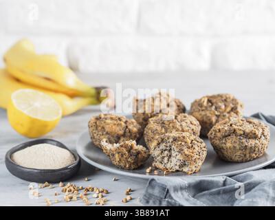 Vue rapprochée d'une homemmade sans gluten muffins aux bananes avec de la farine de sarrasin. Vegan muffins aux graines de pavot sur la plaque en bois Gris sur gris tabl Banque D'Images