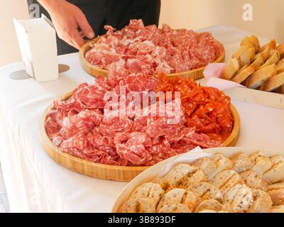 Plateau de charcuterie avec assortiment de charcuteries servi au buffet, parfait pour les mariages, les fêtes ou les réceptions festives. Banque D'Images