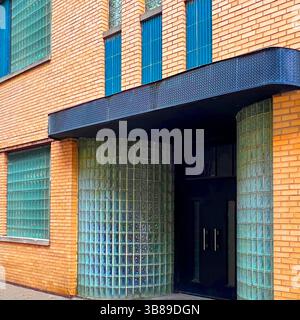 Streamline moderne Entrance avec des murs en blocs de verre incurvés et des accents verticaux de carreaux bleus sur une façade en briques jaunes à Chicago Banque D'Images