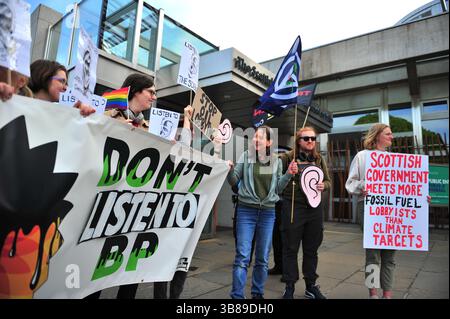 Édimbourg, Royaume-Uni. 13 mars 2025 - des manifestants sont vus tenant des banderoles et des pancartes à l'extérieur du bâtiment du Parlement écossais. Des militants se sont rassemblés devant le Parlement écossais pour s’opposer à une réception de BP, critiquant l’expansion des combustibles fossiles de la société, la baisse des engagements climatiques et l’approvisionnement en pétrole d’Israël. Ils ont exhorté les MSP à rejeter le lobbying des entreprises et à soutenir une transition juste vers les énergies renouvelables. Banque D'Images