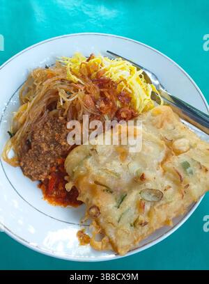 Cuisine indonésienne - Nasi uduk avec bihun goreng ou vermicelles frits, rendang sapi, tempe mendoan et omelette râpée. Banque D'Images
