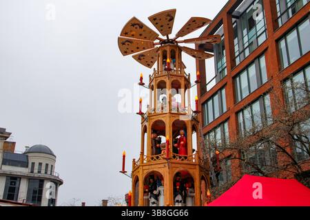 Manchester, Royaume-Uni - 11.16.2024 : pyramide allemande festive qui tourne sur les marchés de Noël de Manchester - le décor de Noël traditionnel attire les foules à Albert Square Banque D'Images