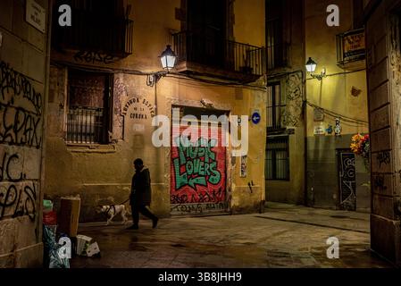 28 janvier 2024, Barcelone, Espagne : un homme promène un chien dans les rues solitaires du quartier gothique de Barcelone au crépuscule. (Crédit image : © Jordi Boixareu/ZUMA Press Wire) Banque D'Images
