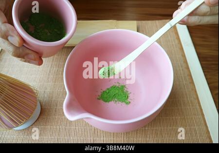 Scooping Matcha Tea Powder avec Bamboo Tea Scoop appelé CHASHAKU pour faire du thé vert Banque D'Images
