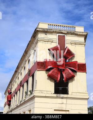 Un bâtiment de Cebu City, aux Philippines, est enveloppé d'un ruban rouge géant et d'un noeud, ressemblant à un cadeau de Noël. La structure est un point de repère historique. Banque D'Images