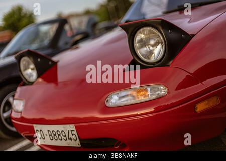 Rome, italie 4 mai 2025 : gros plan des phares rouges mazda mx-5 miata garés dans un parking, mettant en valeur le design automobile et la culture automobile Banque D'Images
