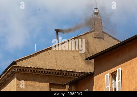 CITÉ DU VATICAN – 8 mai 2025 : de la fumée noire s'élève de la cheminée de la Chapelle Sixtine le deuxième jour du Conclave pontifical, comme on le voit sur la basilique Pierre et la place Pierre. La fumée indique qu'aucun nouveau pape n'a encore été élu. Photo de Marco Ciccolella / Alamy Live News. Banque D'Images