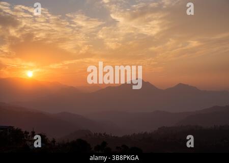 Coucher de soleil sur l'Himalaya. Le soleil plonge derrière les montagnes, créant une belle lueur orange. Banque D'Images