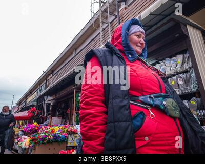 Kiev, Ukraine - 24 mars 2025. Les gens se promènent dans un marché de rue animé, parcourant les étals de fleurs colorées et profitant de l'atmosphère animée de la vie quotidienne urbaine. Banque D'Images
