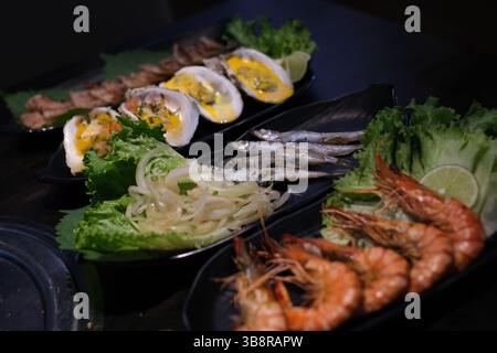 Plat gastronomique de fruits de mer assortis avec moules, saumon, crevettes et poulpe sur une élégante vaisselle. Photo de haute qualité Banque D'Images