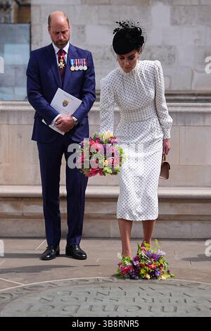 Le prince de Galles regarde la princesse de Galles déposer des fleurs au mémorial des victimes innocentes, à la suite d'un service de Thanksgiving à l'abbaye de Westminster à Londres à l'occasion du 80e anniversaire du jour de la victoire. Date de la photo : jeudi 8 mai 2025. Banque D'Images