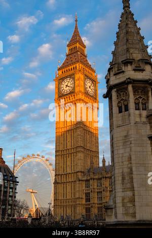 Golden Hour baigne la Tour Elizabeth de Londres (Big Ben) et le London Eye dans une lueur chaleureuse, mettant en valeur des monuments emblématiques. Banque D'Images
