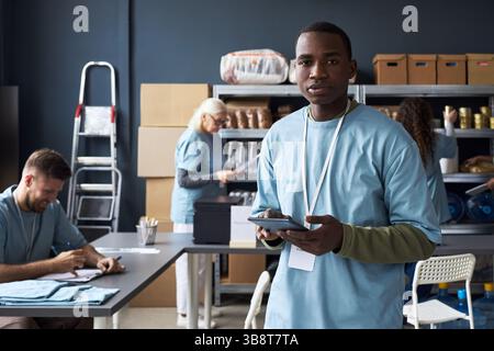 Bénévolat à la banque alimentaire communautaire avec l'équipe multiraciale Banque D'Images