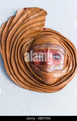 Façonné à partir d'un masque d'argile accroché sur un mur blanc Banque D'Images