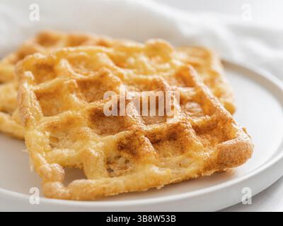 Gaufres à keto délicieuses parfaites. Deux ingrédients s'affle sur une plaque sur fond de marbre blanc. Œufs et gaufres au parmesan. Très proche Banque D'Images