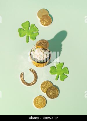 Concept de la St Patrick. Encore plus moderne avec des symboles chanceux et de la nourriture douce pour la fête de la Saint Patrick. Cupckake au velours vert, shamrock, doré c Banque D'Images