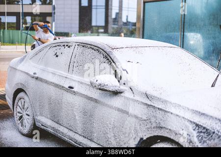 Lavage de voiture manuel avec lavage à haute pression à l'extérieur. Banque D'Images