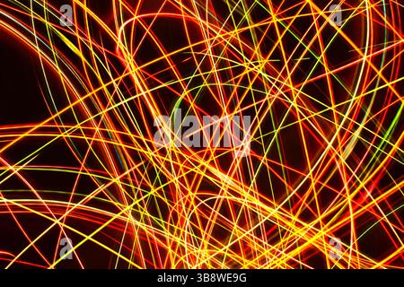Traînées de lumière abstraites colorées avec des lignes de néon brillantes fond sombre motif de mouvement dynamique dynamique dynamique dynamique vibrant mouvement électrique longue exposition. Banque D'Images
