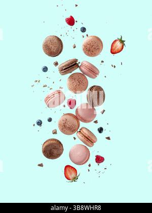 Volez des macarons français. Lévitez la composition avec différents types de macarons colorés en mouvement tombant ou volant sur fond bleu vif Banque D'Images