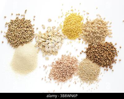 Ensemble de tas divers grains et céréales - sarrasin vert cru, semoule, flocons d'avoine, millet, riz brun, sarrasin ou kasha, quinoa et riz rouge.Isola Banque D'Images