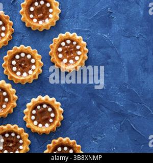 Biscuits au caramel sur fond texturé bleu tendance 2020. Vue de dessus ou plan d'étapage. Couleur de 2020 fond de nourriture et concept avec espace de copie. S Banque D'Images