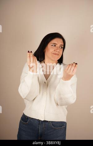 Beaux gestes féminins montrant le vrai goût des pâtes italiennes, n'a jamais mangé rien de plus délicieux, portant des jeans décontractés, pull blanc Banque D'Images
