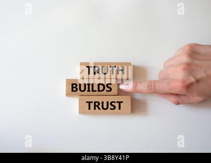 La vérité construit le symbole de confiance. Le mot concept Truth construit la confiance sur les blocs de bois. Main d'homme d'affaires. Beau fond blanc. Les affaires et la vérité construisent t Banque D'Images
