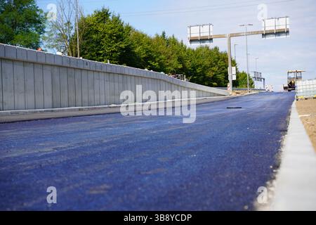 Gros plan détaillé de la surface lisse d'asphalte frais sur une route nouvellement pavée Banque D'Images