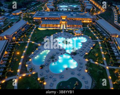 Vue aérienne d'un grand complexe hôtelier de luxe avec piscines, paysages luxuriants et architecture accueillante. Banque D'Images