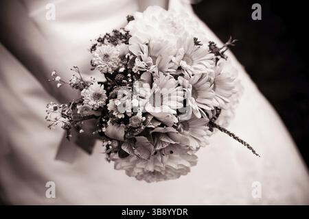 La mariée avec un bouquet de mariage fermer jusqu'à l'extérieur. Champ de profondeur peu profondes, chocolat tonning Banque D'Images