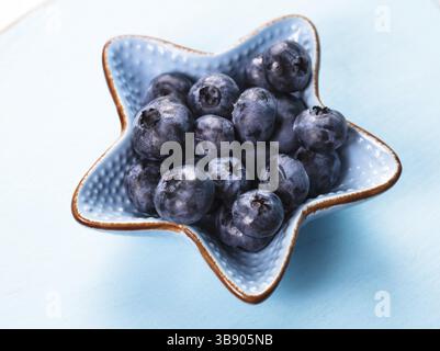 Les bleuets close up dans un bol bleu Banque D'Images