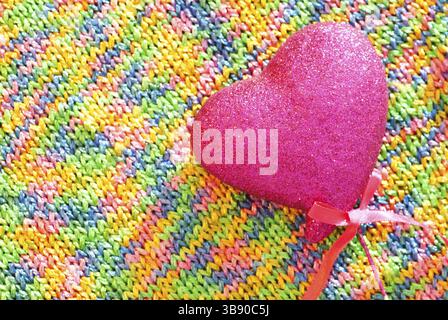 Texture tricotée arc-en-ciel avec coeur rose en gros plan Banque D'Images
