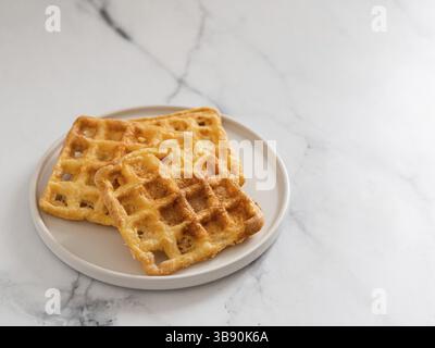 Délicieuses gaufres au keto. Deux ingrédients s'affle sur une plaque sur fond de marbre blanc. Œufs et gaufres au parmesan. Copier l'espace f Banque D'Images