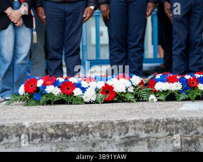 Couronnes de fleurs bleues, blanches et rouges posées pour une cérémonie commémorative, symbolisant les couleurs nationales françaises et un hommage commémoratif. Banque D'Images