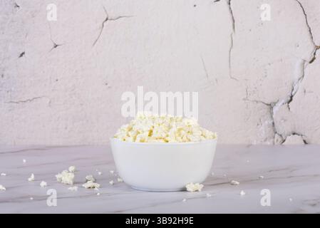 Fromage cottage frais dans un bol blanc gros plan. Alimentation saine. Banque D'Images